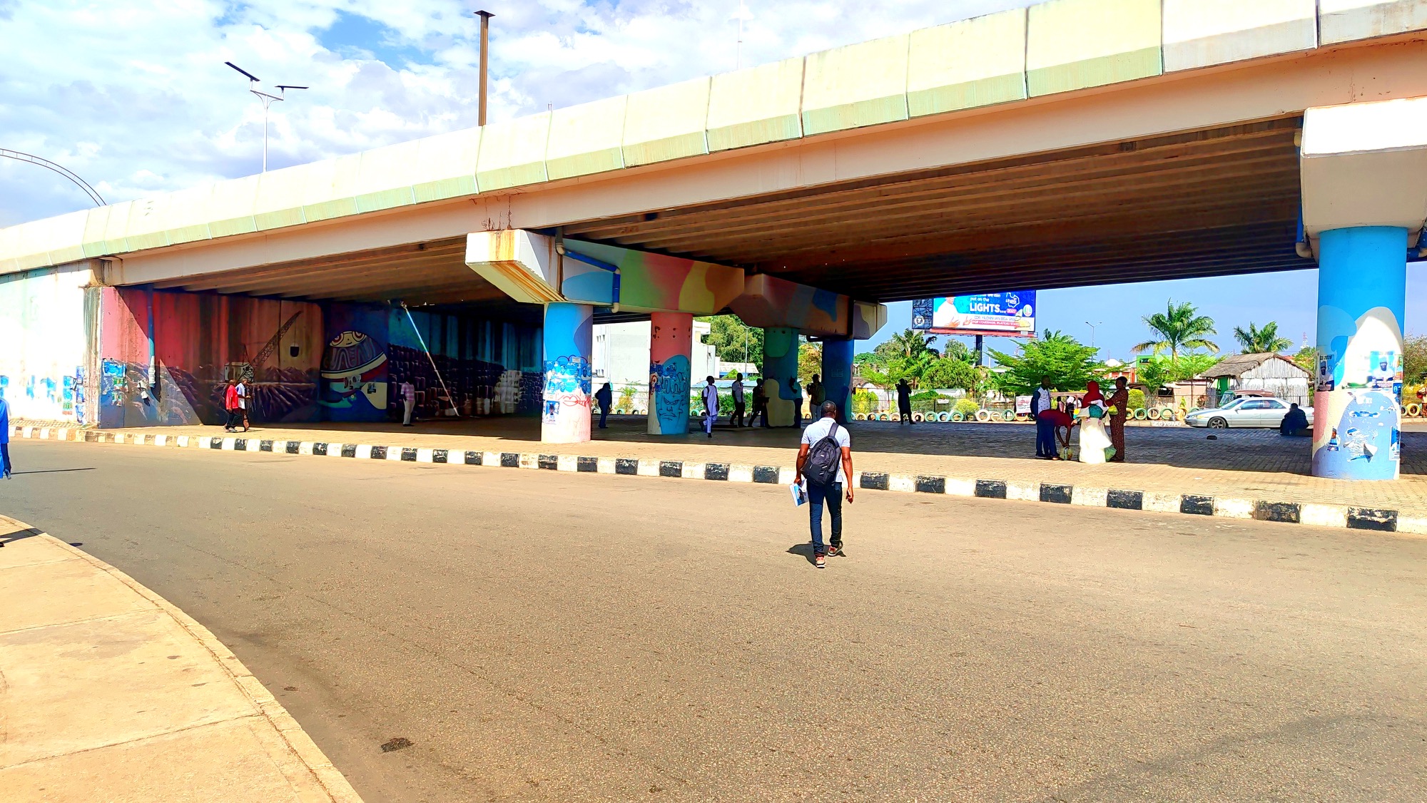 Roadside travel scene in Nigeria under a flyover